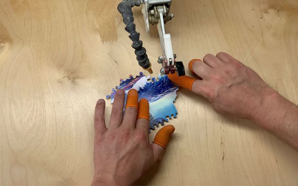 hand cutting a puzzle